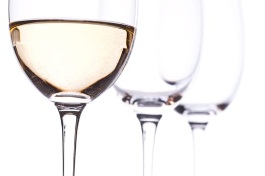 Three glasses backlit,one of them with white wine