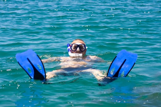 man in the water with fins mask and snorkel