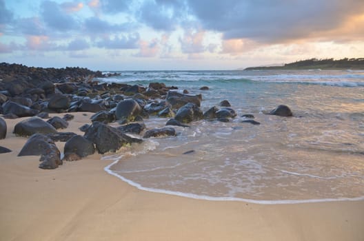 beautiful beach with big rocks in sunset