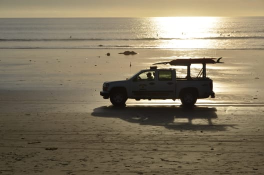 Sunset with baywatch car at the beach of San Diego