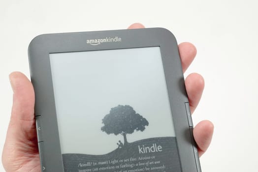 adult holding a kindle reader on a white background