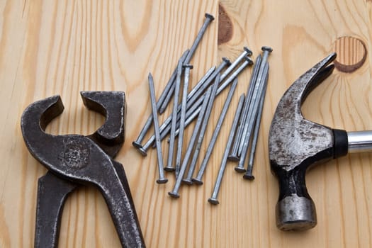 Old hammer,wrench and nails on wood background
