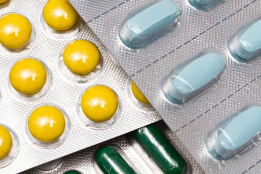 Colorful pills and capsules closeup on white background