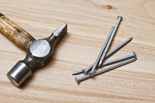 Old hammer and nails on wood background