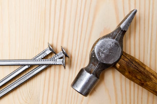 Old hammer and nails on wood background