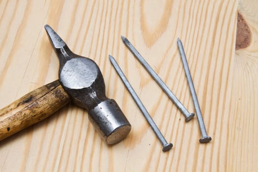 Old hammer and nails on wood background