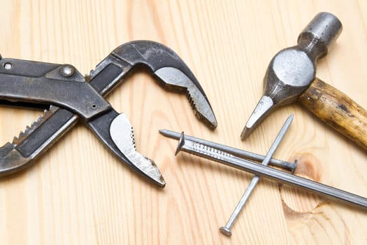 Old hammer and nails on wood background
