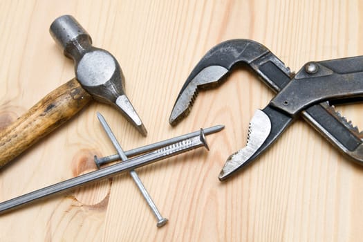Old hammer and screw on wood background