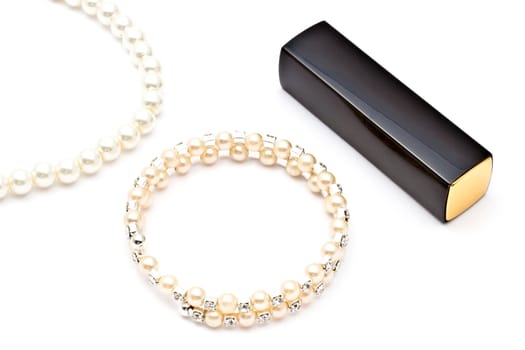 Pearl bracelet ,necklace and listick on white background