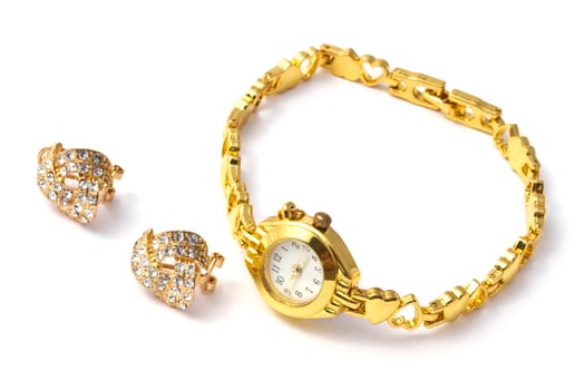 golden wrist watch and earrings on white background