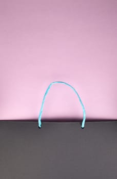 Paper bag with handles on pink cardboard