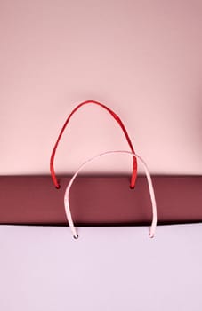 Paper bag with handles on pink cardboard