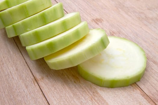 fresh green zucchini on wood background