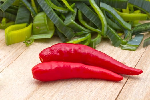 Fresh leek and red chili pepper on wood background