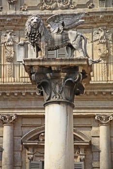 The Lion of St. Mark - here a symbol of Venice's rule - on a column in Piazza delle Erbe in Verona in front of Palazzo Maffei,Italy
