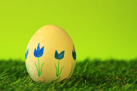 Easter decoration made of single,colorfully painted,Easter egg in green artificial grass