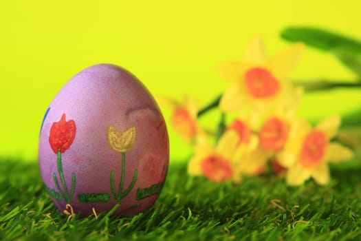 Easter decoration made of single,colorfully painted,Easter egg in green artificial grass