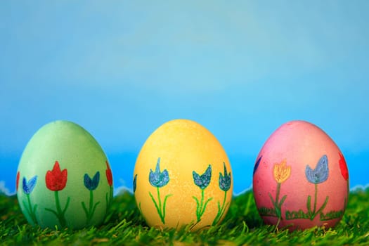 three Easter eggs colourfully painted with floral motifs