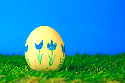 Easter decoration made of single,colorfully painted,Easter egg in green artificial grass