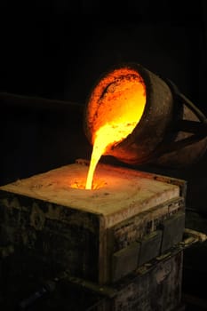 Foundry - molten metal poured from ladle into mould - lost wax casting