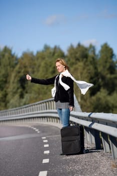 Hitchhiking woman alone at the side of the road