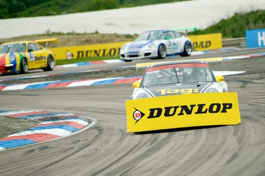 Steve Parish gets a large sponsorship banner stuck to the front of his car during a Porsche Carrera Cup race at Thruxton, UK - May 1, 2011