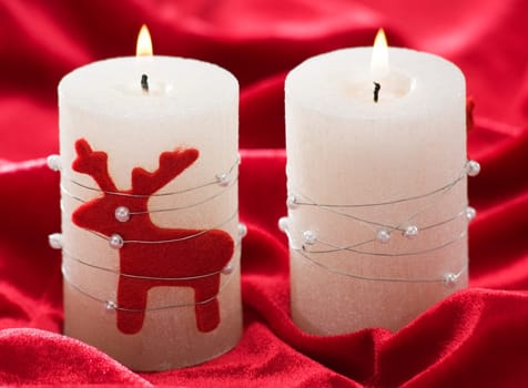 christmas candles on red background close up
