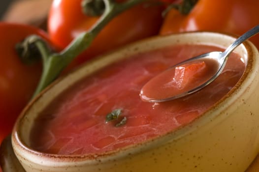 tomato soup with tomatoes in background close up