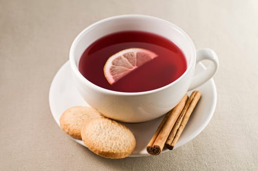 Cup of hot tea with lemon and cookie close up