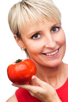 young blond woman holding ripe tomato close up