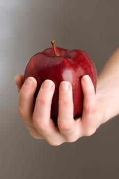 red apple in womans hand close up