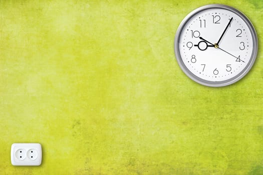 electric socket and clock on the green wall