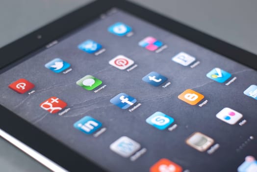a black tablet with social media icons and a shallow depth of field