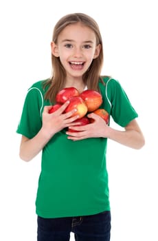Front view of pretty little girl holding several apples on white background.