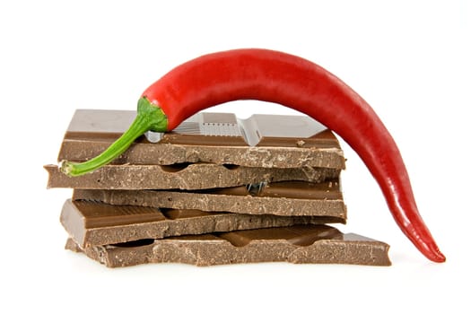 Red chili pepper on stack of dark chocolate