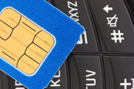 gsm  sim card on  the top of a phone keypad