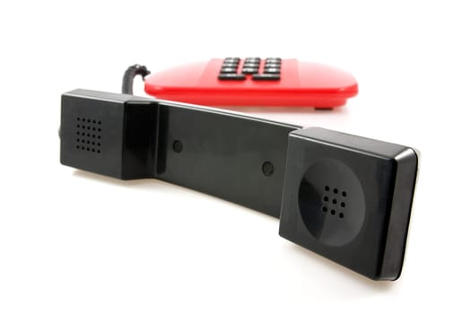 red telephone with black receiver over a white background
