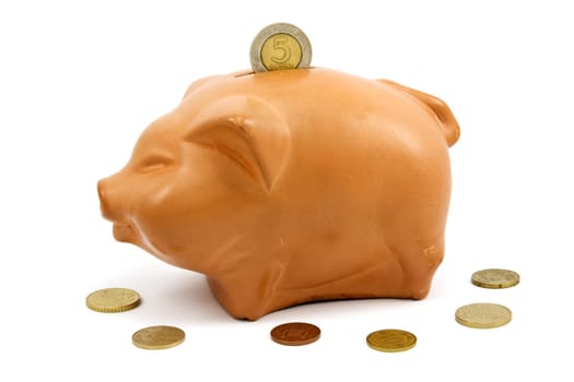 brown piggy-bank and coins over a white background