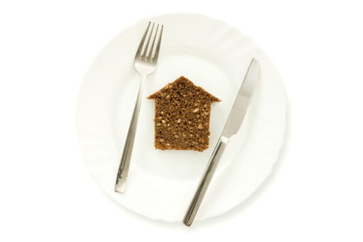 The silhouette of the house from bread lays on a plate