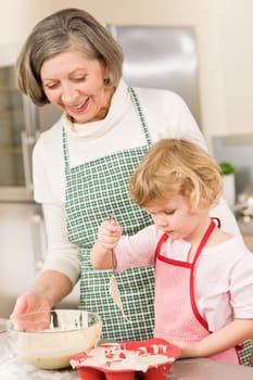 Woman and little girl make cupcakes together fill baking form