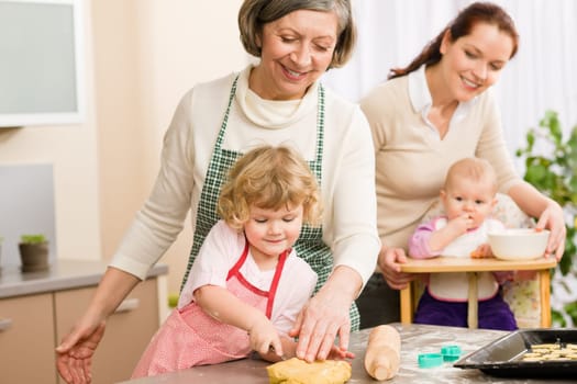 Grandmother with little girl prepare dough for baking in kitchen