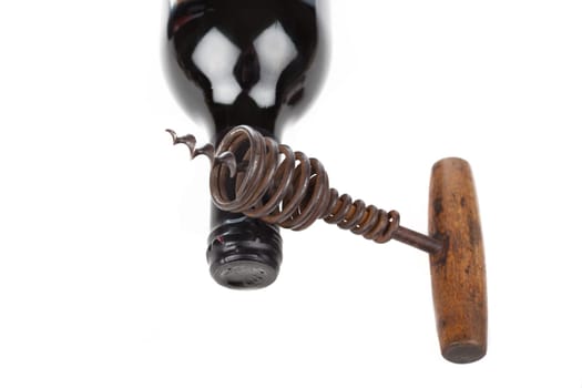 Corkscrew and wine bottle against white background