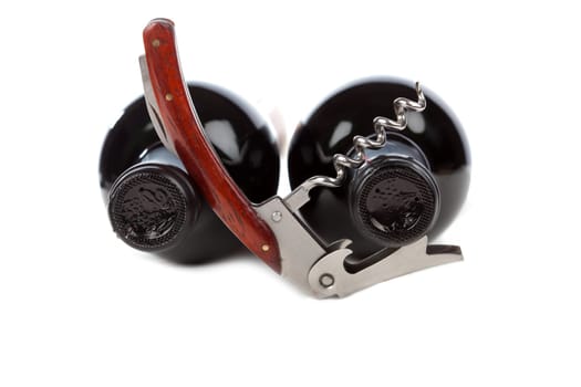 Two wine bottles with corkscrew against white background