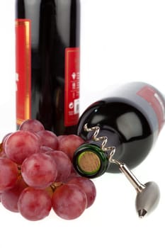 Wine bottle with corkscrew and grapes
