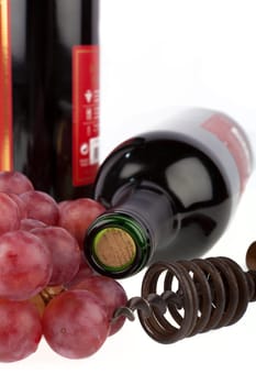 Wine bottle with corkscrew and grapes