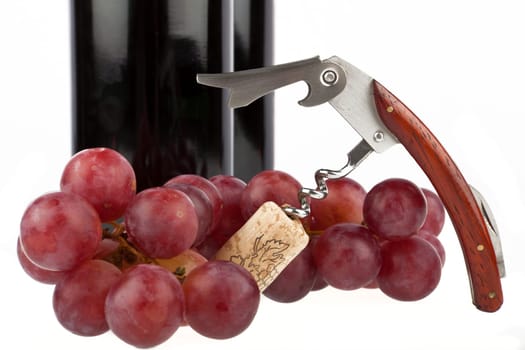 Wine bottle with corkscrew and grapes
