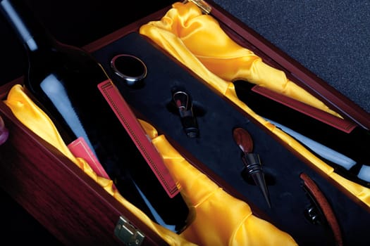 Wine bottle in decorative gift box with wine cutlery