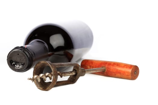 Corkscrew and wine bottle against white background