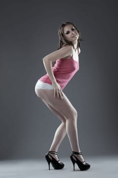 Sexy young girl stand in white panties and rose tank top