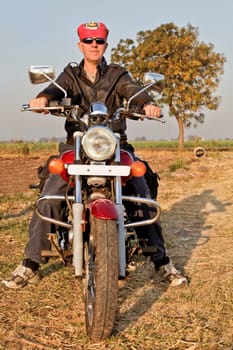portrait of an european biker with headgear in the farmlands and hinterlands of Gujarat, India